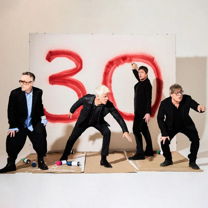 Matchbox Twenty's four members posing in front of a hand-sprayed red 30 for their 30th anniversary